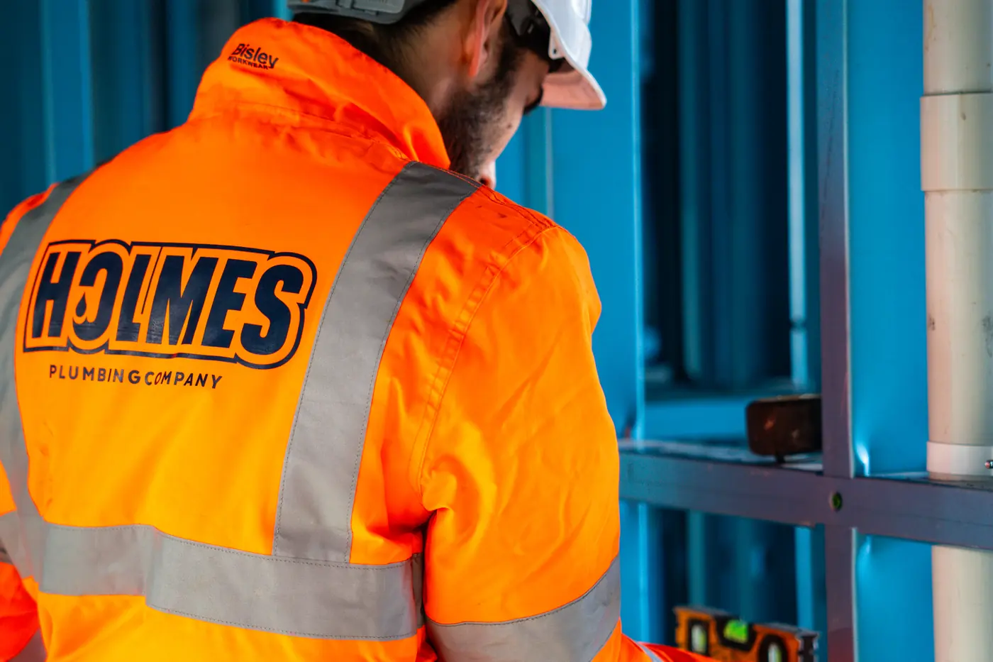 Holmes Plumbing Company plumber at work inside a townhouse frame in Prahran